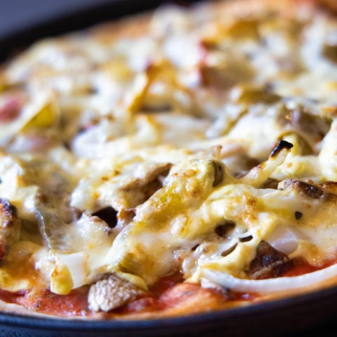 Dönerpizza mit Käse überbacken auf dem Blech